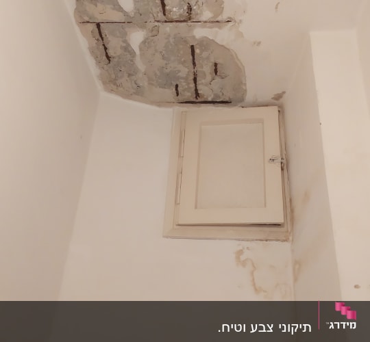 תקרה מתקלפת עם סימני רטיבות וקיר לבן